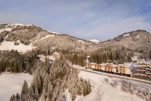a train traveling down the tracks near a mountain at Bergresort Tauernblick by ALPS RESORTS in Mittersill