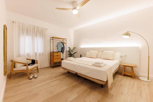 a bedroom with a bed and a chair in it at Bravissimo Maragall, very spacious and central in Girona