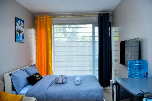 a living room with a blue couch and a window at Mex Homes Studio in Nairobi