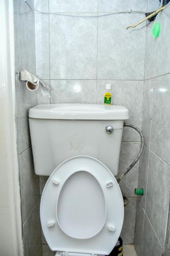 a bathroom with a white toilet in a room at Mex Homes Studio in Nairobi