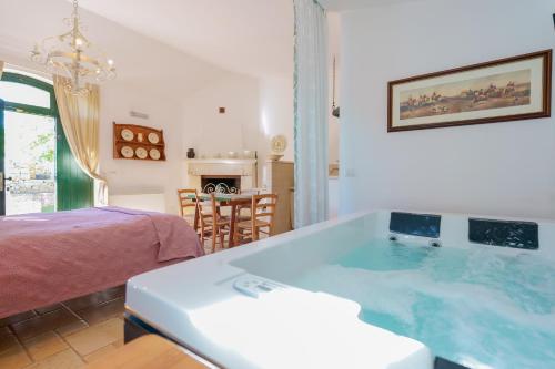a bath tub in a room with a bed at Masseria Rosa Trulli Relais in Alberobello