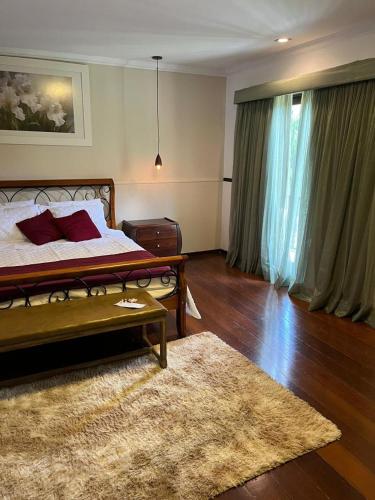 a bedroom with a large bed and a rug at Recanto dos Vianas in Teresópolis