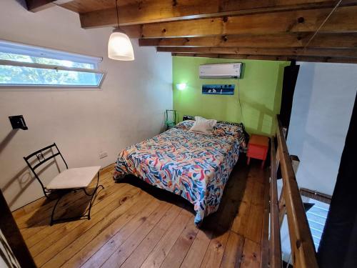 Un pequeño dormitorio con una cama y una silla. en Casa en Laguna de Lobos, en Lobos
