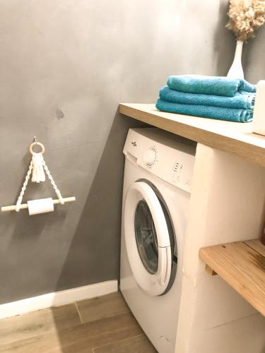 a laundry room with a washing machine on a shelf at Le studio du Coutach in Quissac