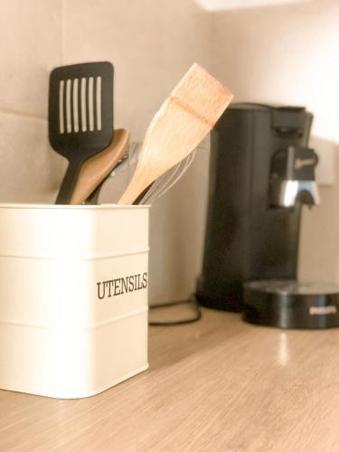 a container with a wooden spatula and a knife at Le studio du Coutach in Quissac