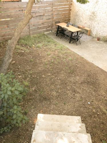 a picnic table and a bench in a yard at Le studio du Coutach in Quissac
