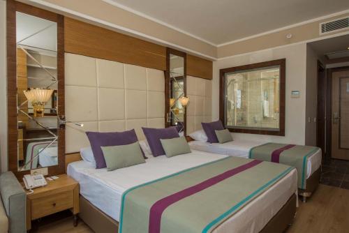 een hotelkamer met twee bedden en een spiegel bij Dream World Aqua in Side
