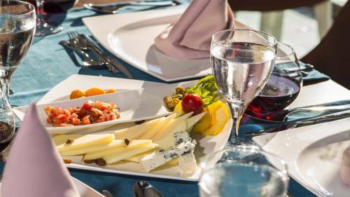 un tavolo con un piatto di cibo e bicchieri di vino di Dream World Aqua a Side