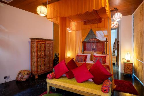 a bedroom with a canopy bed with red pillows at Aathma Colombo House in Colombo