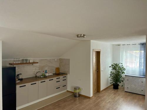 a kitchen with white cabinets and a sink in it at Apartmani Sun & Moon in Žepče