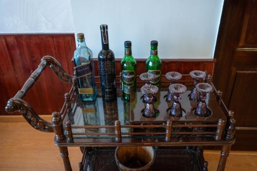 a cart full of bottles and glasses on a table at Wizards Den-Harry Potter inspired 3BHK in Mashobra in Mashobra