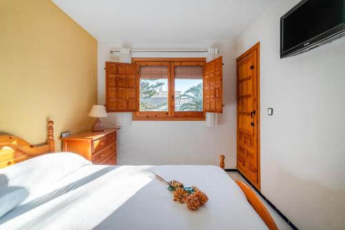 una camera da letto con un letto bianco e una finestra di Casa en la playa con piscinas costa a Santa Pola