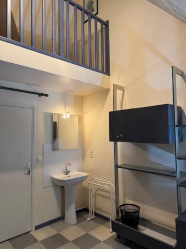d'une petite salle de bains avec un lavabo et un escalier. dans l'établissement Chambre meublée en duplex indépendante, à Caen