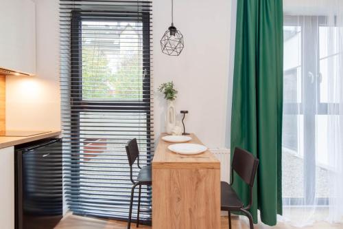 a kitchen with a table and chairs in a room at Apartamenty Silver Place in Szczecin