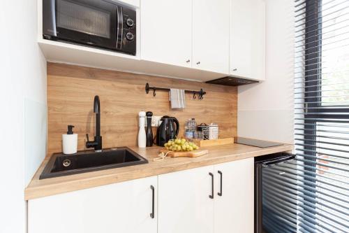 a kitchen counter with a sink and a microwave at Apartamenty Silver Place in Szczecin