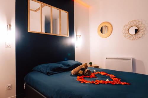 a teddy bear laying on a bed with a flower arrangement at Evasion romantique & spa in Saint-Étienne