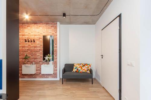 a living room with a couch and a brick wall at Apartamenty Silver Place in Szczecin