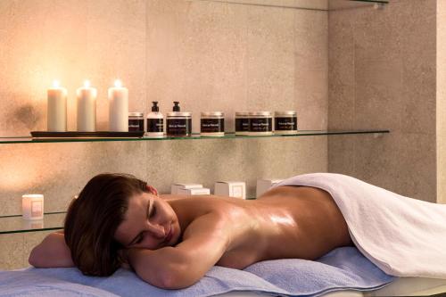 a naked woman laying on a towel in a bath room at Eva Park Life & Spa in Konstancin-Jeziorna