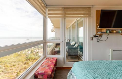 Un dormitorio con un gran ventanal con vista al mar. en My House is Yours Espectacular Departamento Vista al Mar Temporada Verano, en Viña del Mar