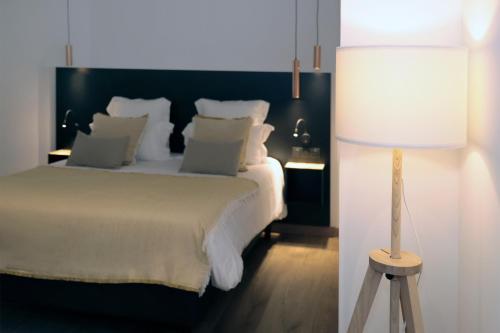 a bedroom with a white bed and a lamp at Le Néliö in Aix-en-Provence