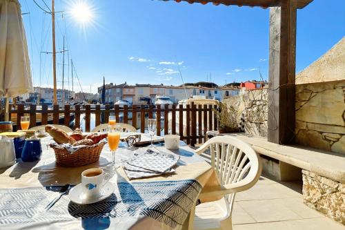 une table sur un balcon avec vue sur un port dans l'établissement Big fisherman house with WIFI and a mooring close to the beach, à Grimaud