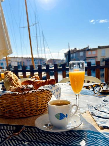 - une table avec une tasse de café et un verre de jus d'orange dans l'établissement Big fisherman house with WIFI and a mooring close to the beach, à Grimaud