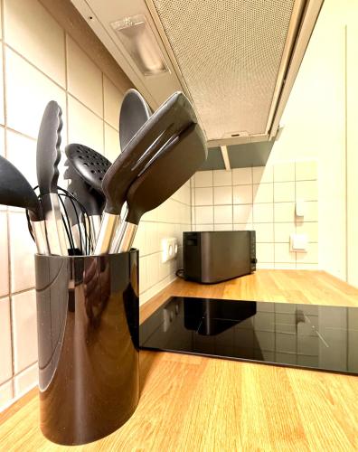 a vase filled with utensils on a kitchen counter at Traumwerk24 - Altstadt Suite Augsburg in Augsburg