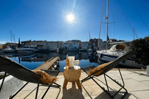- deux chaises et une table sur un quai dans l'établissement Renovated fisherman house next to the beach - AC WIFI mooring, à Grimaud