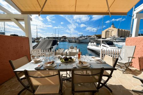 - une table sur une terrasse avec vue sur le port de plaisance dans l'établissement Fisherman house with WIFI AC and a 14m-mooring, à Grimaud
