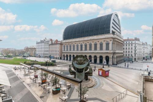 un grand bâtiment avec une horloge devant lui dans l'établissement Studio Pradel - Welkeys, à Lyon
