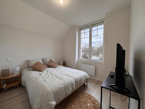 a bedroom with a bed and a television in it at Le Petit Victor in Tavaux