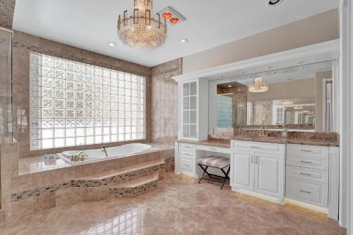 a bathroom with a tub and a sink and a mirror at Spacious Luxury Villa in Hollywood 6BR 5-Bath 5-Min Walk to Beach & Attractions in Hollywood