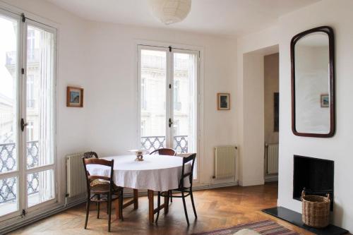 une salle à manger avec une table, des chaises et un miroir dans l'établissement Nice T3 near the must-see places of Paris, à Paris