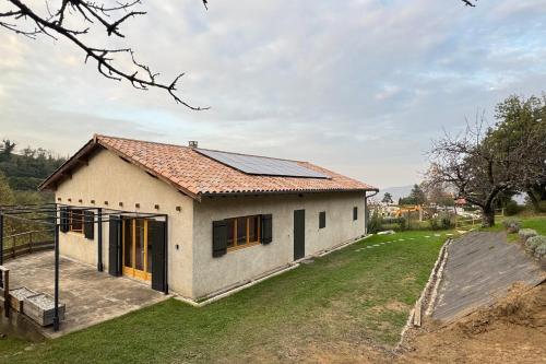 une petite maison avec des panneaux solaires sur le toit dans l'établissement Belles-Vues - Ozon, à Ozon