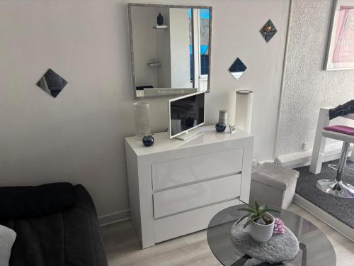 - un salon avec une commode blanche et un miroir dans l'établissement Cosy Studio Port Cap d'Agde, au Cap d'Agde