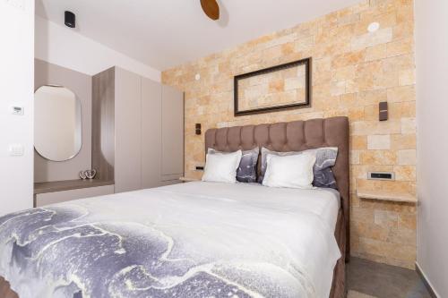 a bedroom with a large bed with a brick wall at Villa Vista Jelsa in Jelsa
