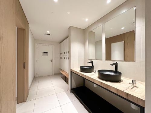 a bathroom with two sinks and a mirror at Trophy - Beach Daze Condo in Lamer W Sea Views in Dubai