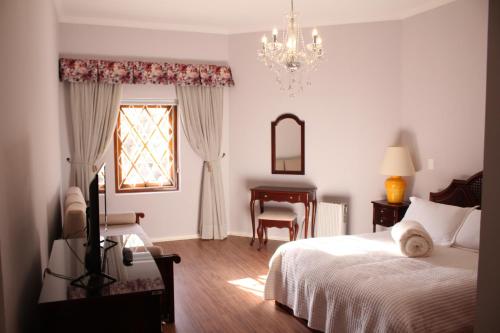a bedroom with a bed and a chair and a window at Center Suiço Flats in Campos do Jordão