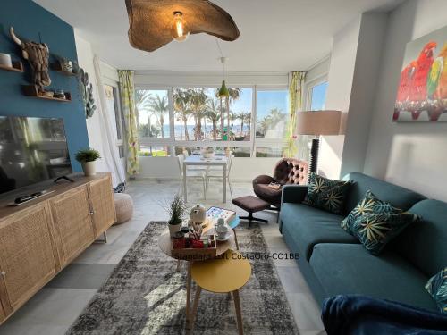 a living room with a blue couch and a table at Primera línea playa Apart 1 Bed CostaOro-CO1BA DELUXE Seafront ó Loft-Studio CostaOro-CO1BB STANDARD in Torrox Costa