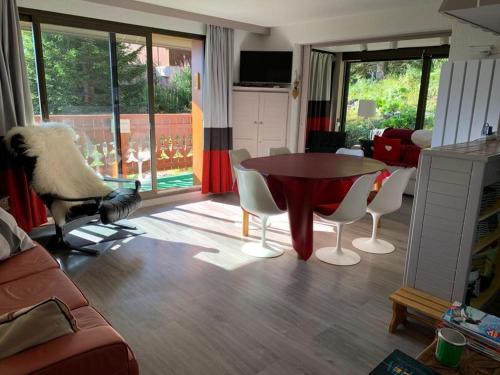 un salon avec une table, des chaises et un oiseau dans l'établissement Campanules, à Courchevel