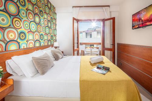 a bedroom with a large white bed with a yellow blanket at Hotel Argentina in Grado