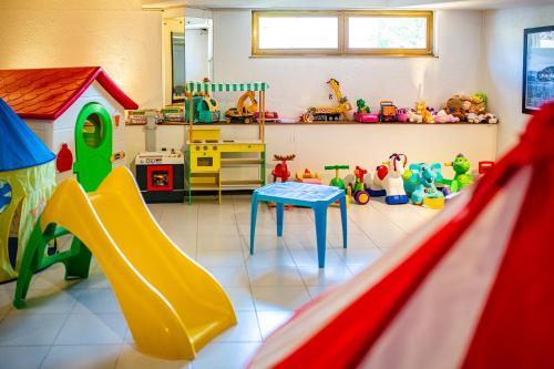 a play room with a slide and many toys at Hotel Argentina in Grado