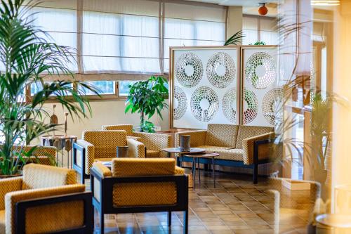 a lobby with chairs and tables and plants at Hotel Argentina in Grado