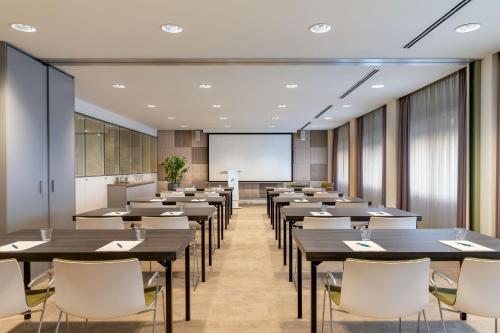 a conference room with tables and chairs and a screen at Element Amsterdam in Amsterdam