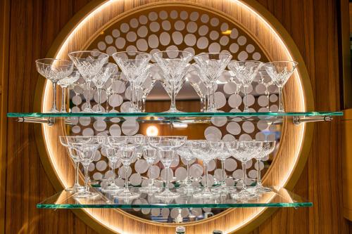 a bunch of wine glasses on a shelf at Hotel Argentina in Grado