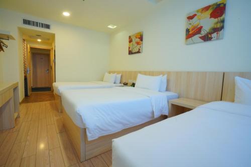 a hotel room with two beds with white sheets at Guangdong Baiyun City Hotel in Guangzhou