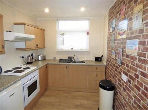 een keuken met een wastafel en een bakstenen muur bij 3 Bedroom Detached Holiday Chalet SouthShore Park in Bridlington