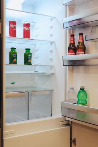 an open refrigerator filled with bottles of soda at Guli's Suite - Lusso e Comfort in Centro Storico in Naples