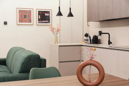 a kitchen with a green couch and a chair at Guli's Suite - Lusso e Comfort in Centro Storico in Naples