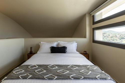 a bedroom with a large bed with a window at Fari Stone Villas in Skala Marion
